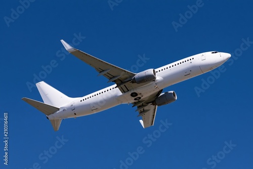 The Commercial Airplane Ascending Over Bright Blue Sky in Flight