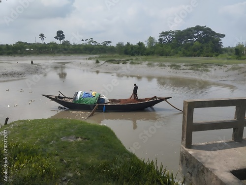 Принти на полотні A traditional wooden fishing boat rests on the murky banks of a tranquil river i