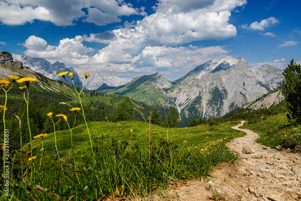 Obraz premium Fernblick auf das Kawendelgebirge mit steinigem Bergpfad und grüne Wiesen, Kawendel, Tirol,Österreich.