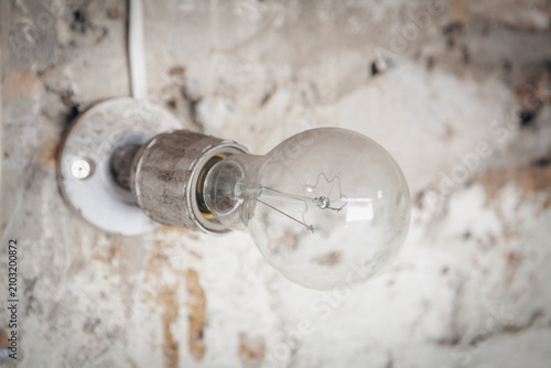 Foto Vintage Light Bulb on Old Wall Background, Idea concept.