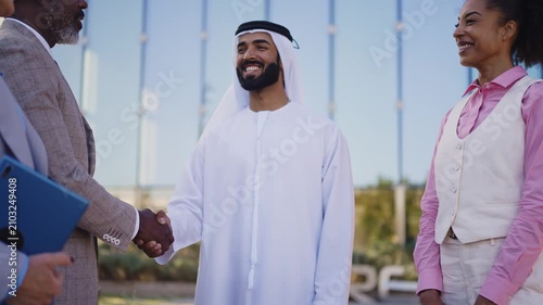 Group of multiethnic business people meeting an emirati businessman - International corporate business team bonding outdoors in the city
