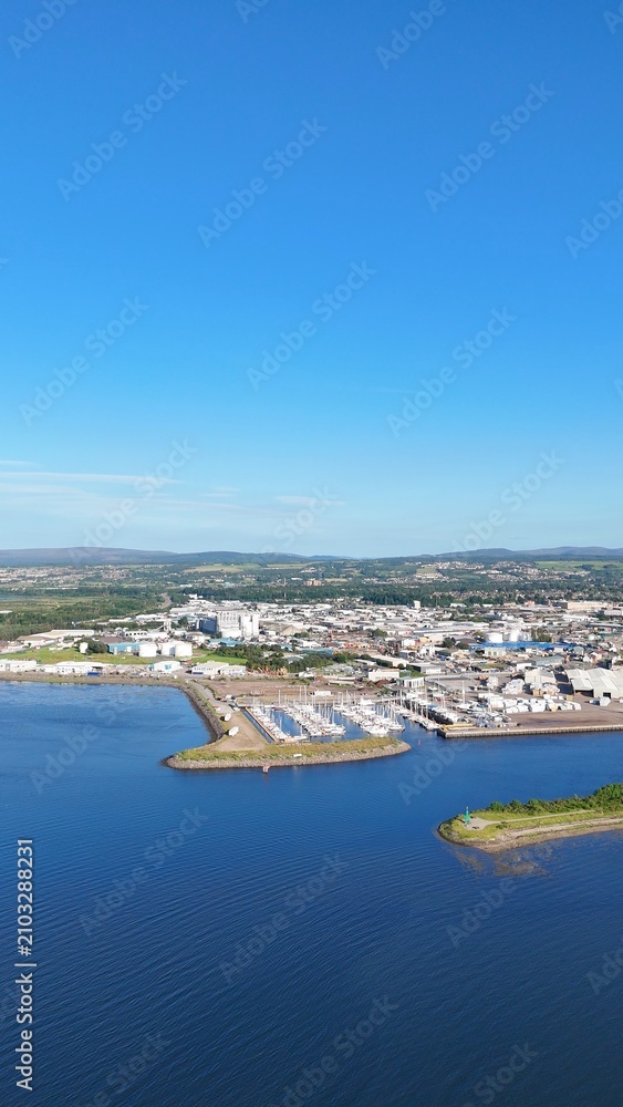 Obraz premium Wide distant view of Inverness, Scotland, British Highlands, revealing the river, green lands, sea edge, and cloudy daytime scenery.