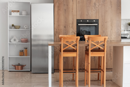 Quadro su tela Interior of modern kitchen with built-in oven, shelf unit and table
