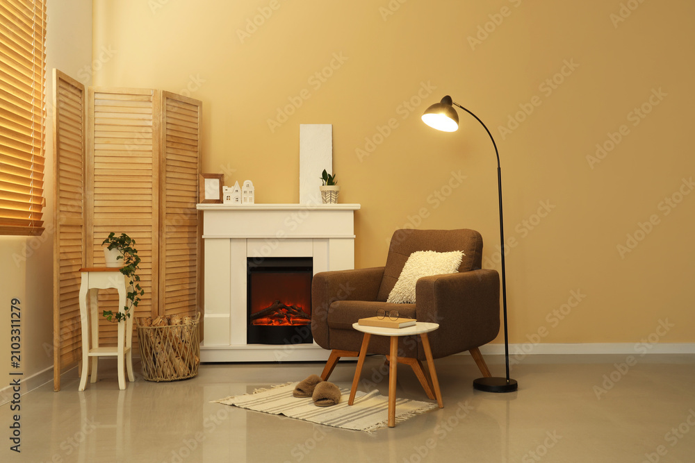 Obraz premium Interior of living room with glowing lamp, armchair and fireplace
