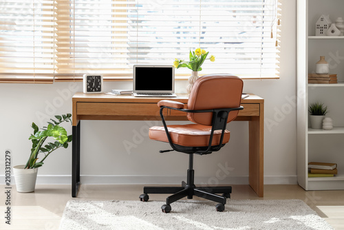 Blank laptop and vase with ...