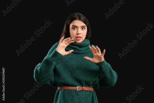 Scared young woman on black...