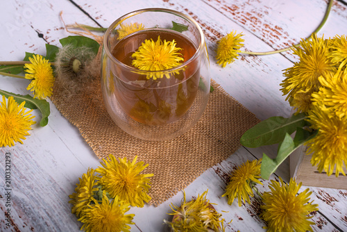 Fotografía Top view of a glass mug filled with healthy dandelion tea decorated with a yello
