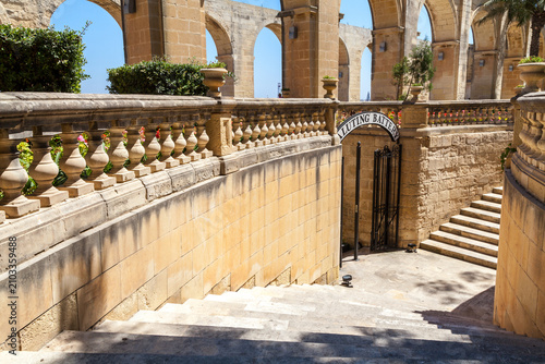 Stone stairs and balustrades lead to the Saluting Battery beneath limestone arches at Upper Barrakka Gardens in Valletta, Malta