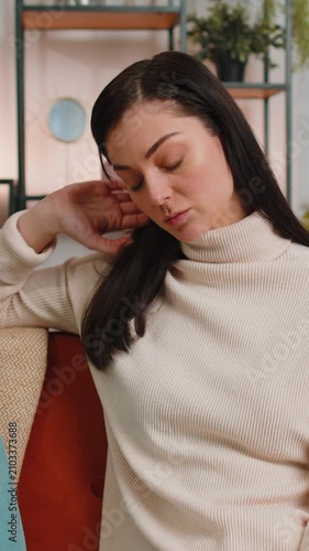 Sad lonely brunette woman sitting at home room looks pensive thinks over life concerns or unrequited love suffers from unfair situation. Lady problem, break up, depressed feeling bad annoyed burnout