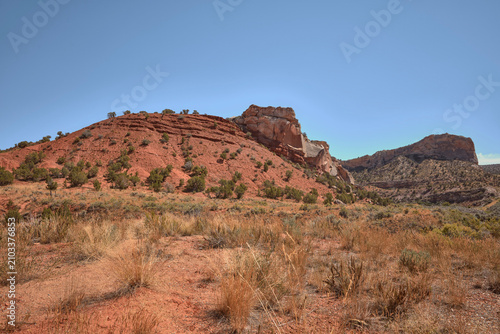 Red rock hillside with sandstone outcrop and juniper trees