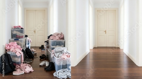 The transformation from a cluttered hallway with storage bins to a clean organized space.