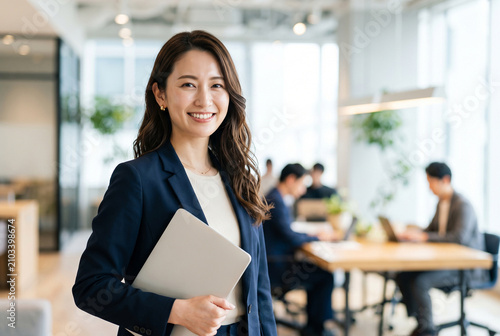オフィスでPCを抱え微笑む日本人ビジネス女性 Generative AI