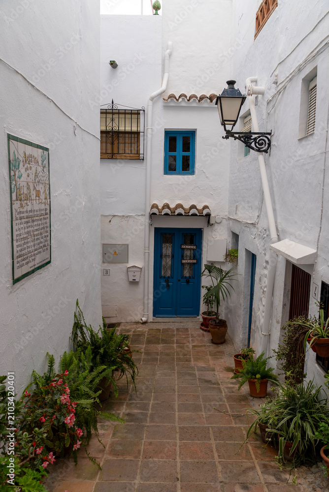Fototapeta premium Charming White Alley with Blue Door in Mediterranean Village