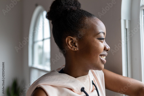 Tableau sur toile Joyful woman gazing outside window.