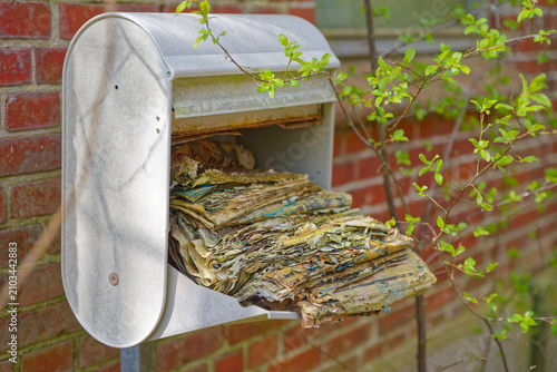 Принти на полотні Old weathered newspapers overflowing from rusty metal mailbox outdoors in nature