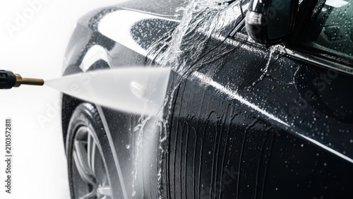High pressure car wash with water spray on black vehicle, professional auto detailing and exterior cleaning service, manual pressure washer rinsing dirt off luxury automobile bodywork