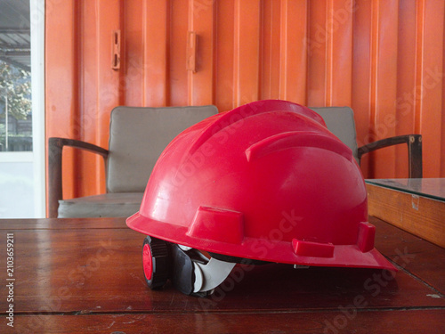 Red Industrial Safety Helmet on Wooden Table in Construction Site Office