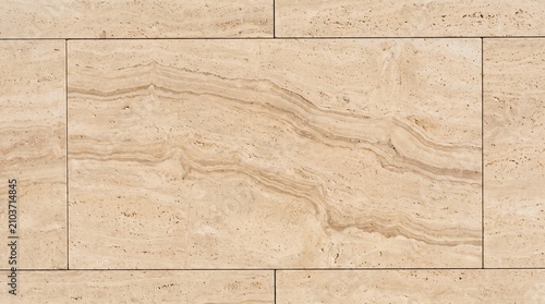 Close up of a beige marble wall with natural wavy patterns.