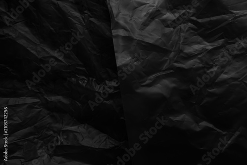 Black background plastic wrinkle bag film glossy crumpled overlay package rough wrap material pack reflection texture floor packaging retail grain pollution trash polyethylene, halloween backdrop.