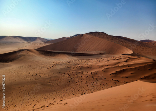Tableau sur toile desert landscape with towering sand dunes under a clear blue sky in Sossusvlei Namibia