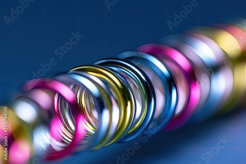 Close-up of shiny metallic party streamers spiraling against a blue background