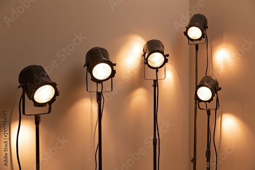Five adjustable spotlights illuminate a neutral wall, creating dramatic light patterns