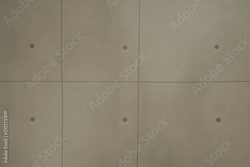 Fotografie Concrete wall with grid pattern and circular indentations
