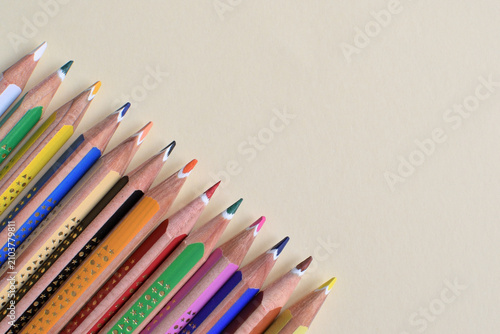 Foto Colored pencils arranged diagonally on a pastel yellow background