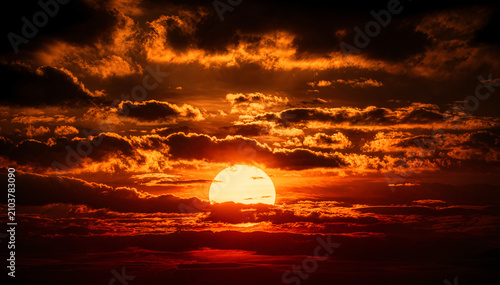 Dramatic Sunset: Low Sun Framed by Layered Dark Clouds
