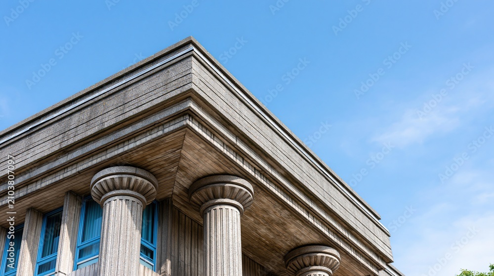 Obraz premium Classic Architectural Columns and Building Facade Against a Clear Blue Sky