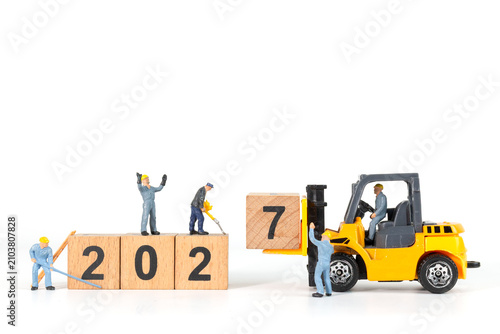 Foto Miniature Workers and Forklift Changing Wooden Blocks from 2026 to 2027 New Year