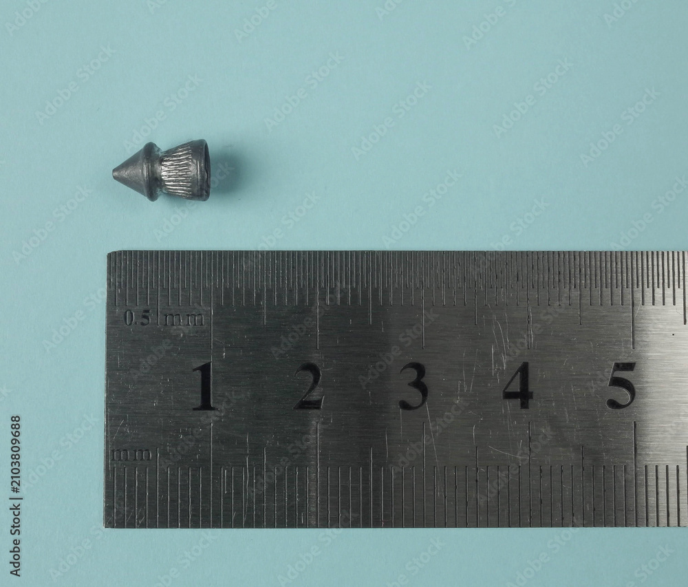 Fototapeta premium bullet of air rifle being measured my ruler centimeters