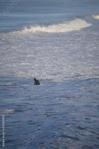 surfer in white water, cold water in winter Aotearoa New Zealand