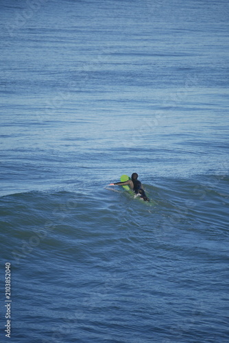 surfer in cold water in winter Aotearoa New Zealand, green surf board