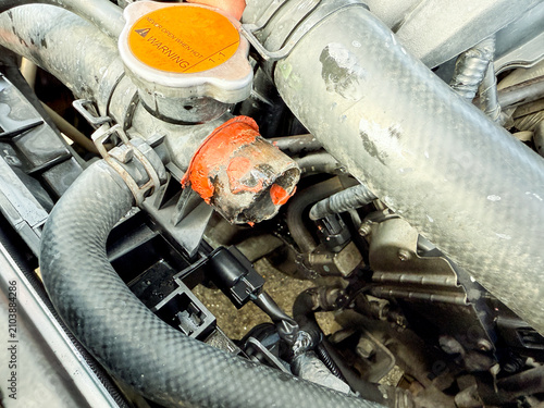 Damaged radiator hose neck with red gasket sealant during engine cooling system repair