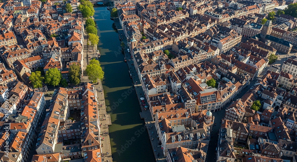 Obraz premium Aerial view of a canal flowing through a busy city residential neighborhood