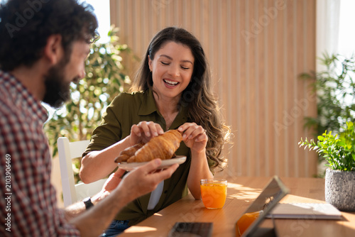 Couple sharing breakfast croissants enjoying morning time