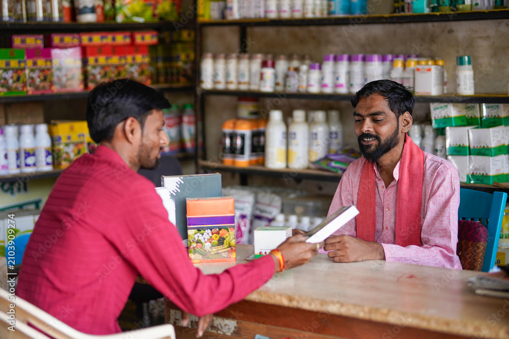 Fototapeta premium indian farmer and fertilizer shop owner discussing while looking some product