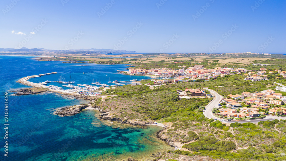 Fototapeta premium Aerial view of Stintino harbor and coastline on the northwestern coast of Sardinia, Italy, overlooking the crystal-clear waters of the Gulf of Asinara