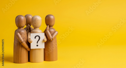 Two wooden mannequin figures holding a question mark sign together, representing shared uncertainty and group decision making