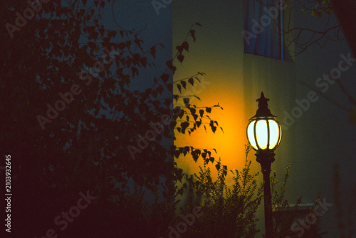 Vintage streetlamp glows warmly in the dark