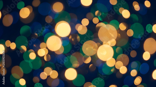abstract christmas background, Abstract background of soft, cinematic bokeh lights in festive shades of gold, navy blue, and emerald green