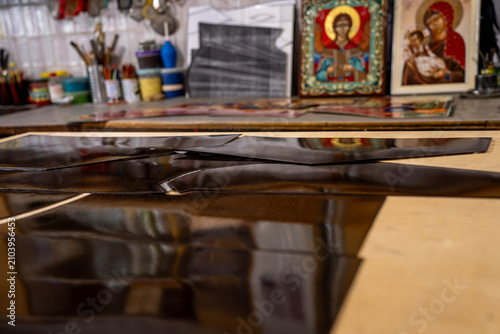 Foto Glossy metal plates coated with dark vitreous enamel layer during production process on a wooden workbench inside a jewelry or artisan craft workshop