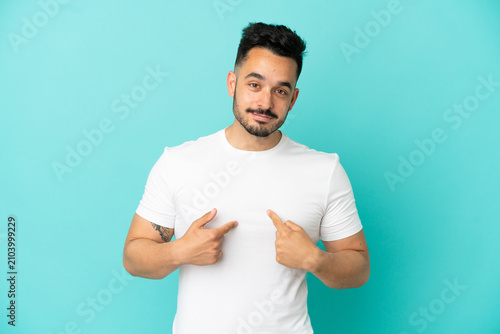 Fotografie Young caucasian man isolated on blue background pointing to oneself