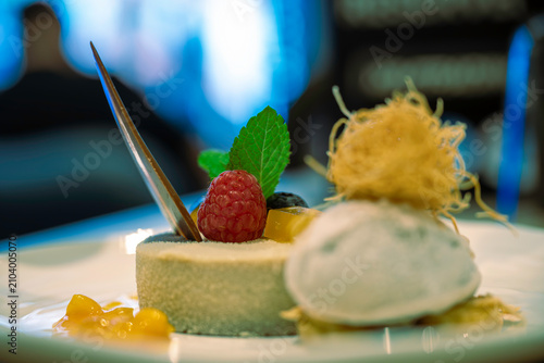 Luxurious ice cream dessert with jam in luxury restaurant. dressed in mint leaves and red berries.