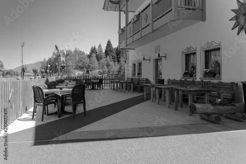 Trentino, Italy - June 2026: Outdoor terrace and bar seating area of Hotel La Pineta in the Italian Alps. The image documents local hospitality, mountain tourism, and traditional alpine architecture i
