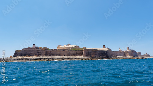 Obraz na plátně Long defensive limestone walls of Fort St Elmo rising above the deep blue sea at