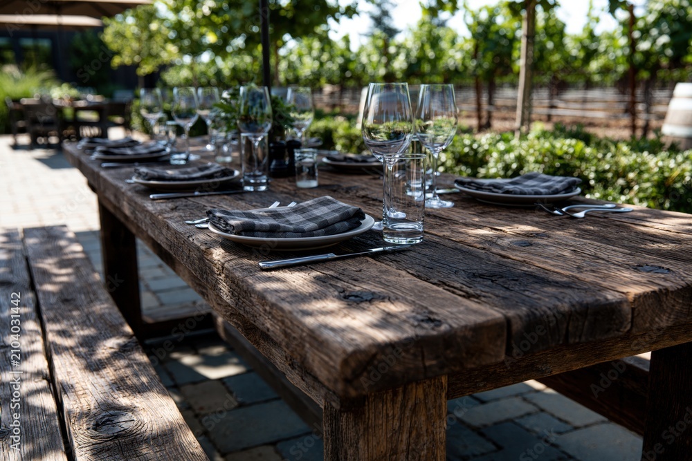 Obraz premium Rustic wooden dining table set in vineyard