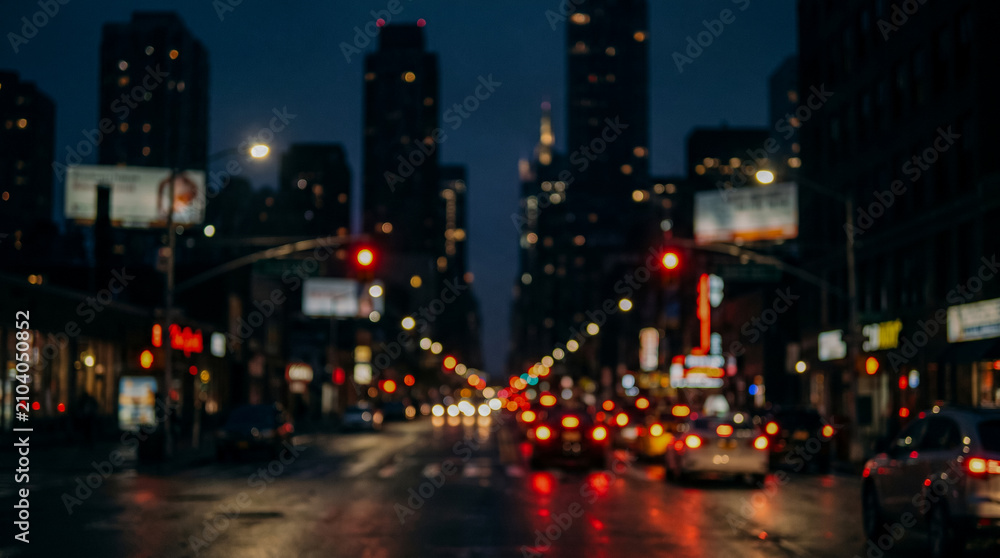 Fototapeta premium Blurred urban street with glowing traffic lights creating a cinematic night background.
