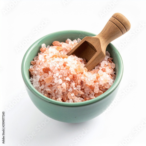 Celadon ceramic bowl with pink salt and wooden scoop on white background
